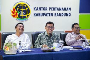 Dari 2.200 Bidang Tanah Milik Pemkab Bandung 700 Bidang Belum Tersertifikasi Bupati Minta Disperkimtan dan BPN Konsolidasi untuk Percepatan iNNews, Bandung- Dari 2.200 bidang tanah yang dimiliki Pemkab Bandung 1.500 bidang sudah tersertifikasi. Sisanya 700 bidang belum tersertifikasi, beberapa bidang di antaranya yang dibangun menjadi sekolah dasar (SD).  Hal tersebut disampaikan Bupati Bandung Dadang Supriatna saat menerima kunjungan kerja Komisi II DPR RI di Kantor Badan Pertanahan Nasional (BPN) Kabupaten Bandung, Jumat 11 Juli 2025. Dadang Supriatna berharap, sisa 700-an bidang tanah yang belum tersertifikasi tersebut bisa secepatnya terselesaikan. "Terutama tanah yang diajdikan sekolah dasar dan ini kerap mengemuka ada kasus penyegelan sekolah oleh oknum yang mengakui ahli waris tanah tersebut," ujarnya. Percepatan penyelesaian aset, menurut Dadang Supriatna penting dilakukan, dalam rangka pengamanan aset berupa tanah, khususnya pengamanan hukum untuk memperjelas legalitas tanah milik Pemkab Bandung. “Selain itu juga dalam rangka peningkatan potensi aset terhadap kontribusi pendapatan asli daerah (PAD). Sehingga saya meminta Disperkimtan untuk menertibkan dan menginventarisir data tanah yang berpotensi terhadap peningkatan PAD,” kata Bupati Bedas ini. Kepada Kepala Disperkimtan dan Kepala Kantor BPN Kabupaten Bandung, Bupati Dadang meminta untuk segera melakukan konsolidasi dalam rangka percepatan tahapan sertifikasi tanah dan pengamanan aset tanah. “Dengan kolaborasi antara Disperkimtan dan BPN ini diharapkan seluruh aset tanah milik Pemkab Bandung lebih jelas legalitasnya, terhindar dari penguasaan dan gugatan pihak lain, serta dapat meningkatkan PAD,” katanya. Sedangkan untuk Program Pendaftaran Tanah Sistematis Lengkap (PTSL) Kabupaten Bandung Dadang Supriatana menyebut dari jumlah 1,2 juta bidang tanah, sudah terealiasi sekitar 900 ribuan bidang.*** Ayi